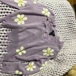 The sweater is a pastel purple and is has flowers on it and it is a small.